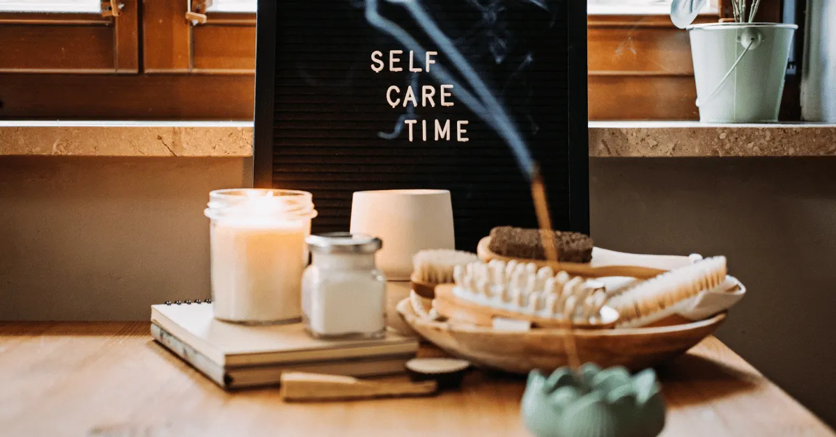 A picture of an emergency self care kit with candles and incense and a board that says self care time.