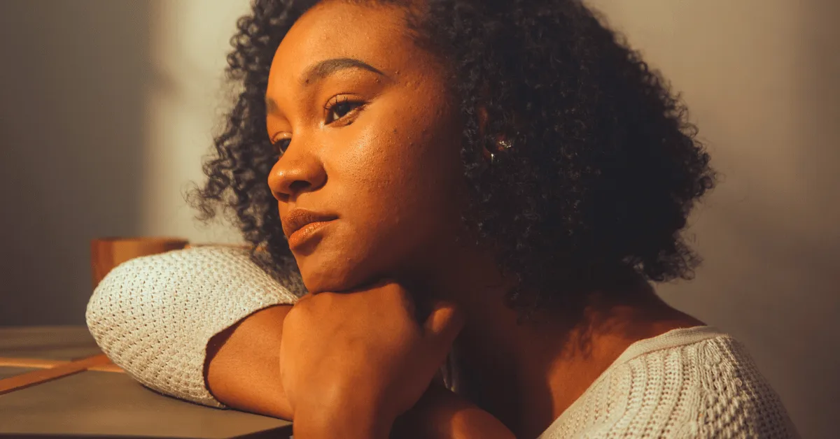 A woman is sitting looking sad.
